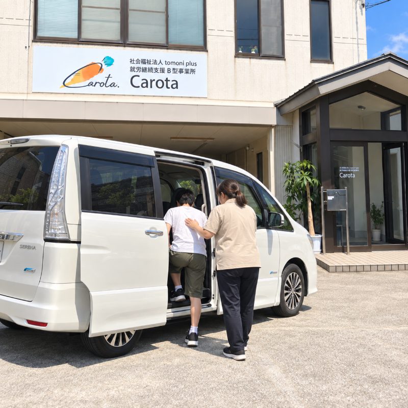 carota の送迎車に、スタッフの介助を受けて乗り込む様子